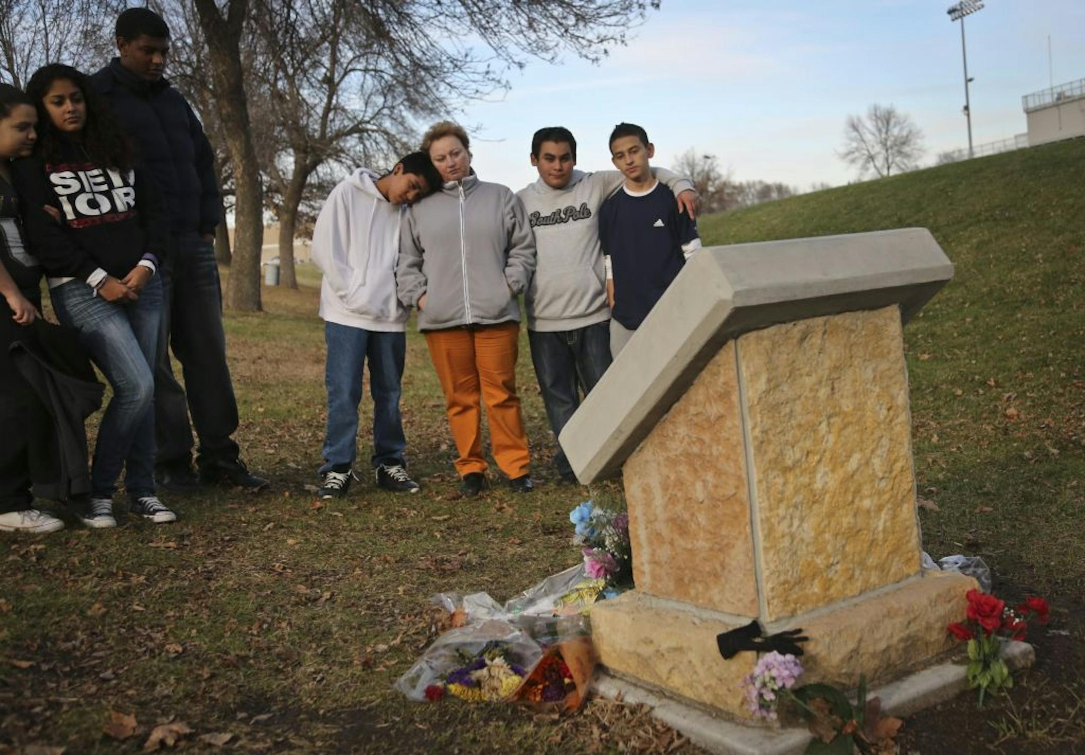 Sergio Ramirez put his head on the shoulder of his teacher Yeugeniya Malikin as they stood with Isaias Contreras, and Axel Martinez at a memorial set up for Clarisse Grime at the spot where she was hit and killed at Harding High School this summer. Photograph was taken in St. Paul, Minn., on Wednesday, November 14, 2012. Also pictured at left is Tatiana Hernandez, Jessica Cervantes and Nesro Wado. All were close friends of the victim. A Ramsey County judge on Wednesday convicted the unlicensed d