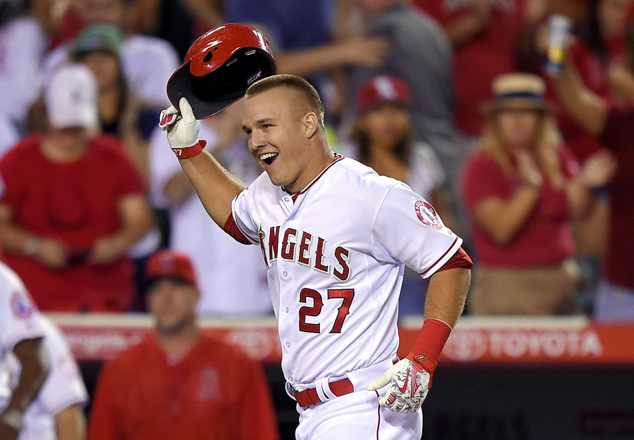 Los Angeles Angels' Mike Trout tosses his helmet as he heads home after hitting a solo walk off home run during the ninth inning of a baseball game against the Boston Red Sox, Friday, July 17, 2015, in Anaheim, Calif. (AP Photo/Mark J. Terrill)