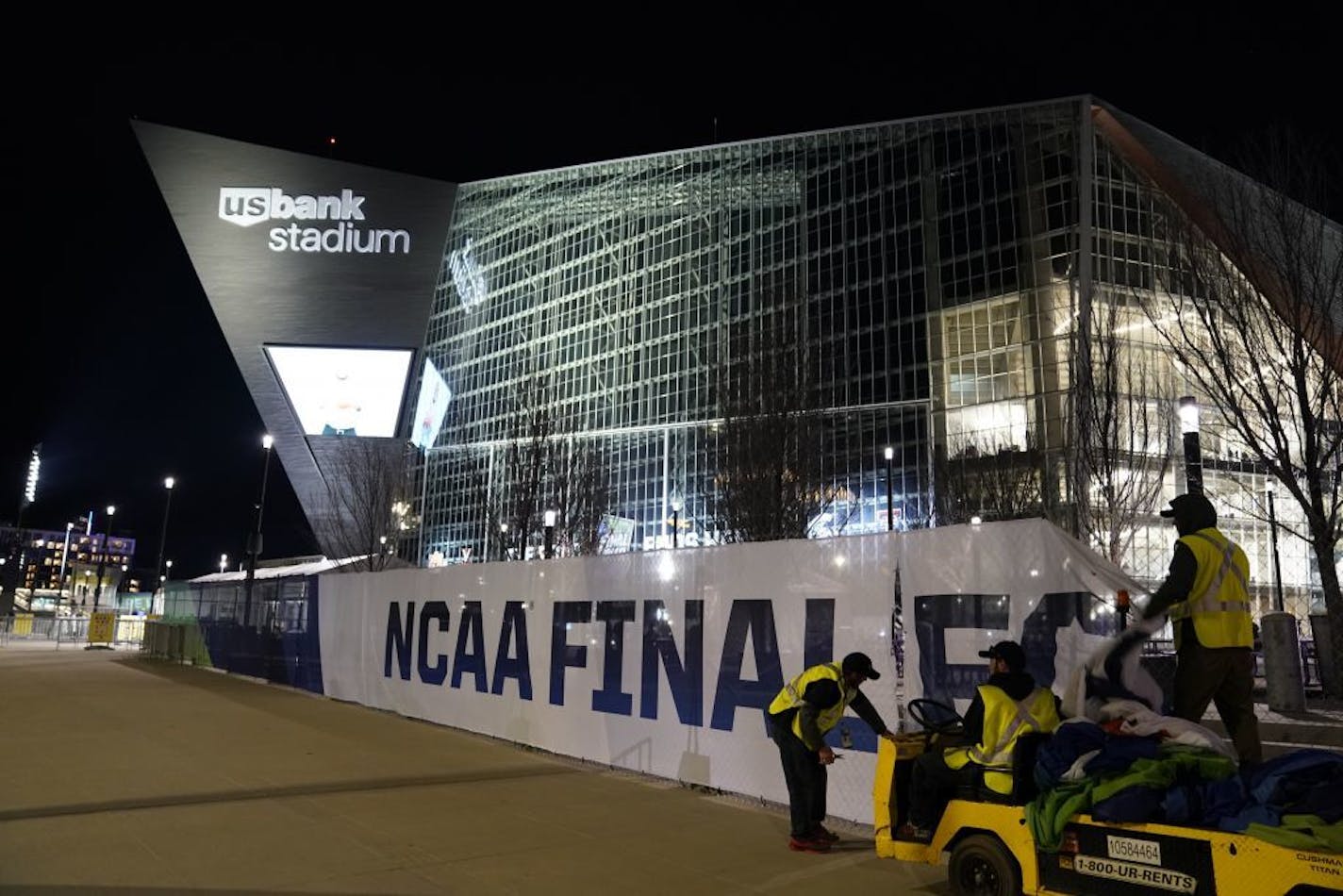 Workers take down NCAA Final Four signage outside U.S. Bank Stadium during the game.