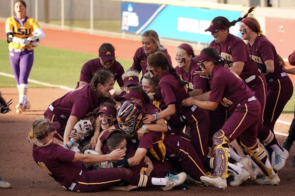 Gophers pitcher Amber Fiser (13) was mobbed by her teammates after getting the win.