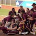 Gophers pitcher Amber Fiser (13) was mobbed by her teammates after getting the win.