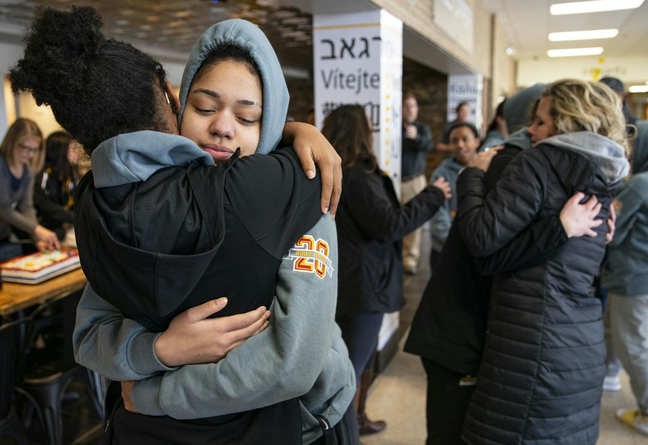 (From left) Duluth Marshall girl's basketball guard Jada Kirk hugged forward Daisa Starks while guard Merlea Mrozik was embraced by her mother, Leah, after returning to school Friday afternoon following the cancelation of the MSHL girl's basketball tournament.