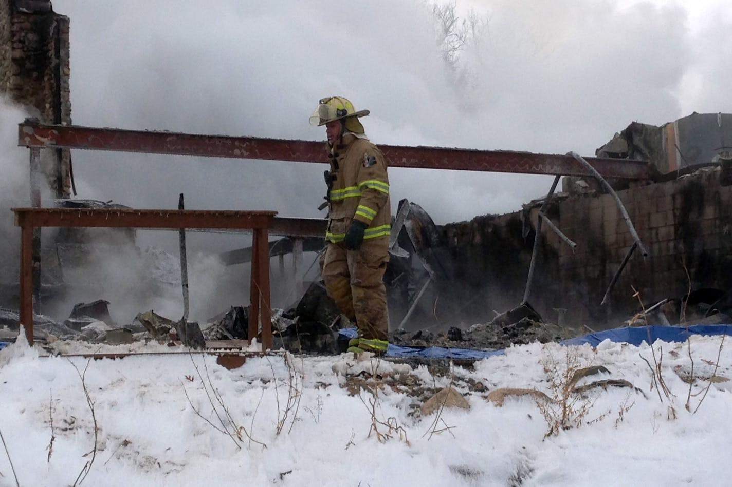 Authorities examine what's left of the restaurant at the clubhouse of the Minnesota Horse and Hunt Club in Prior Lake after fire erupted before dawn Tuesday. The structure was considered a total loss.