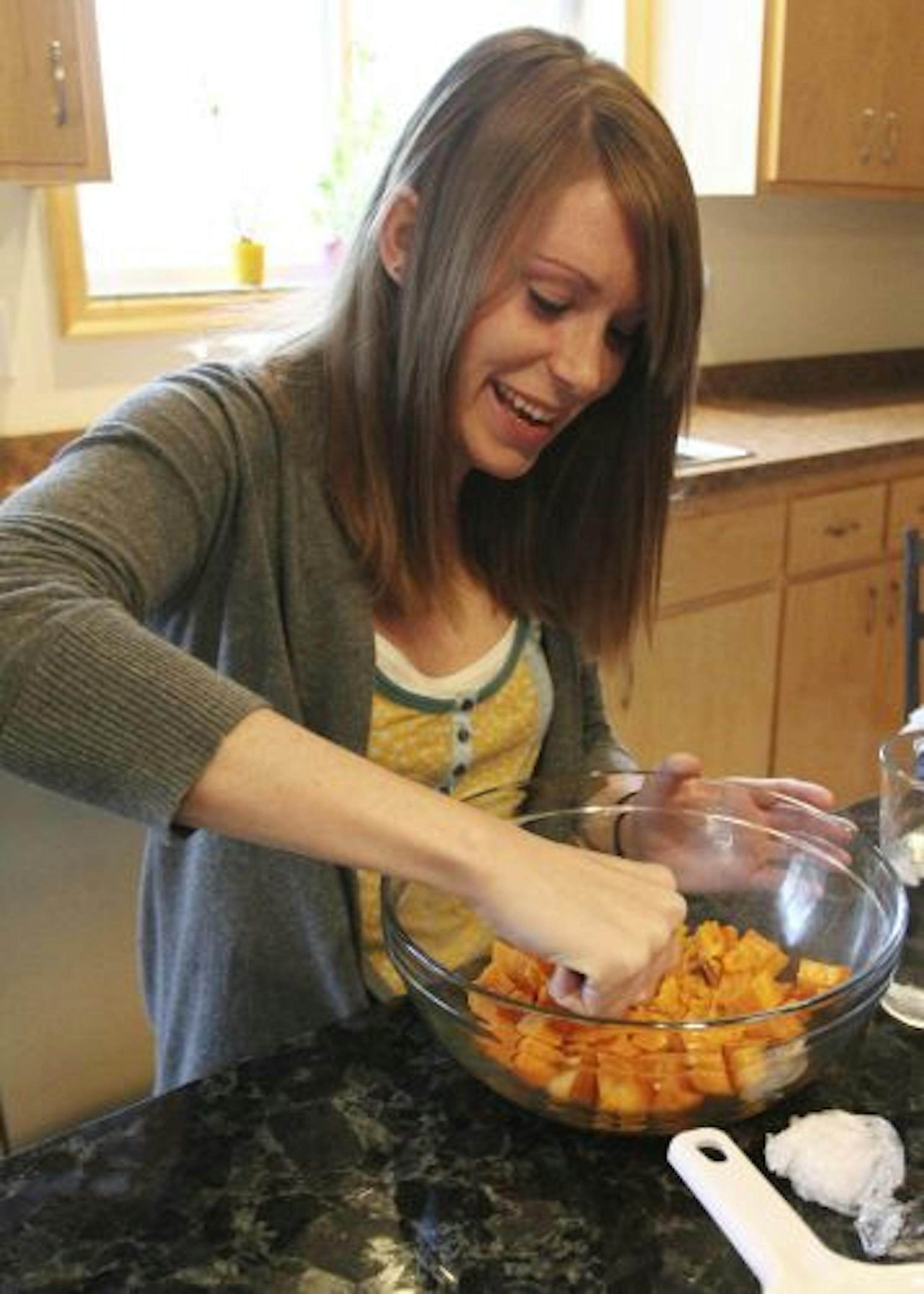 University of Minnesota junior Elise Bailey mashes sweet potatoes during an in-home presentation on healthy eating by the Student Nutrition Advocacy Collaboration.