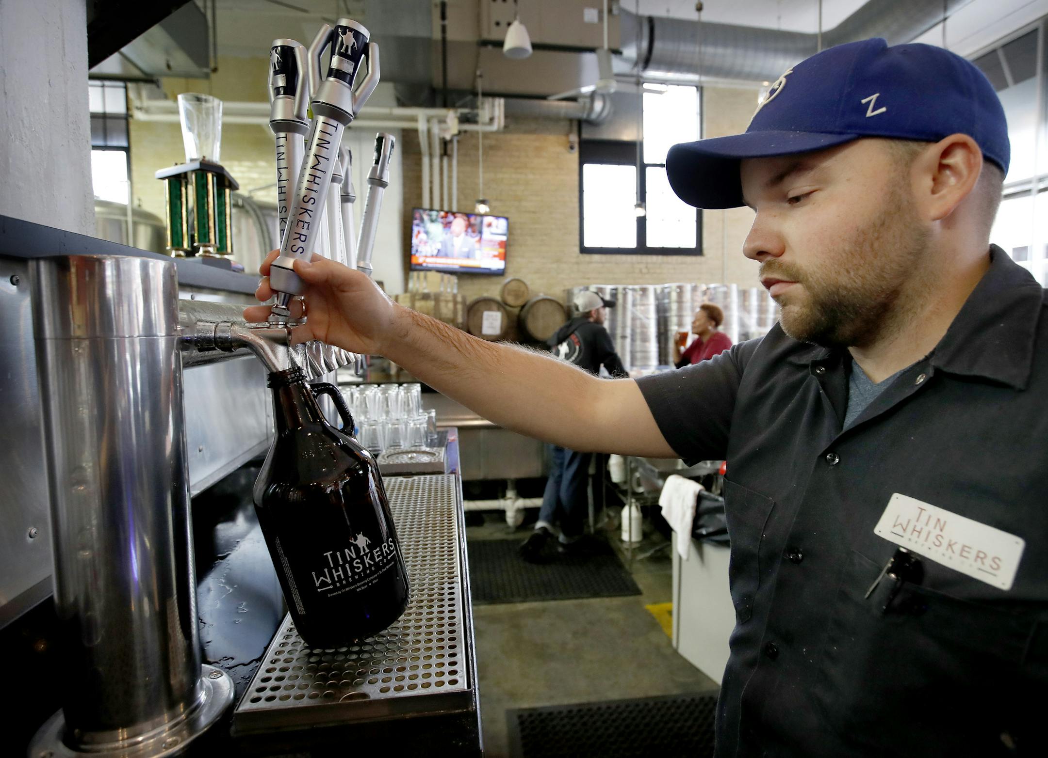 Bartender Ben Kampa filled a growler with Daisy Chain Saison at Tin Whiskers in St. Paul. ] CARLOS GONZALEZ cgonzalez@startribune.com - October 4, 2016, St. Paul, MN, Tin Whiskers, one of the breweries that would be impacted by the change in liquor sale hours. They currently cannot sell growlers after 8 p.m. on weekdays, and this regulatory change would push that to 10 p.m.