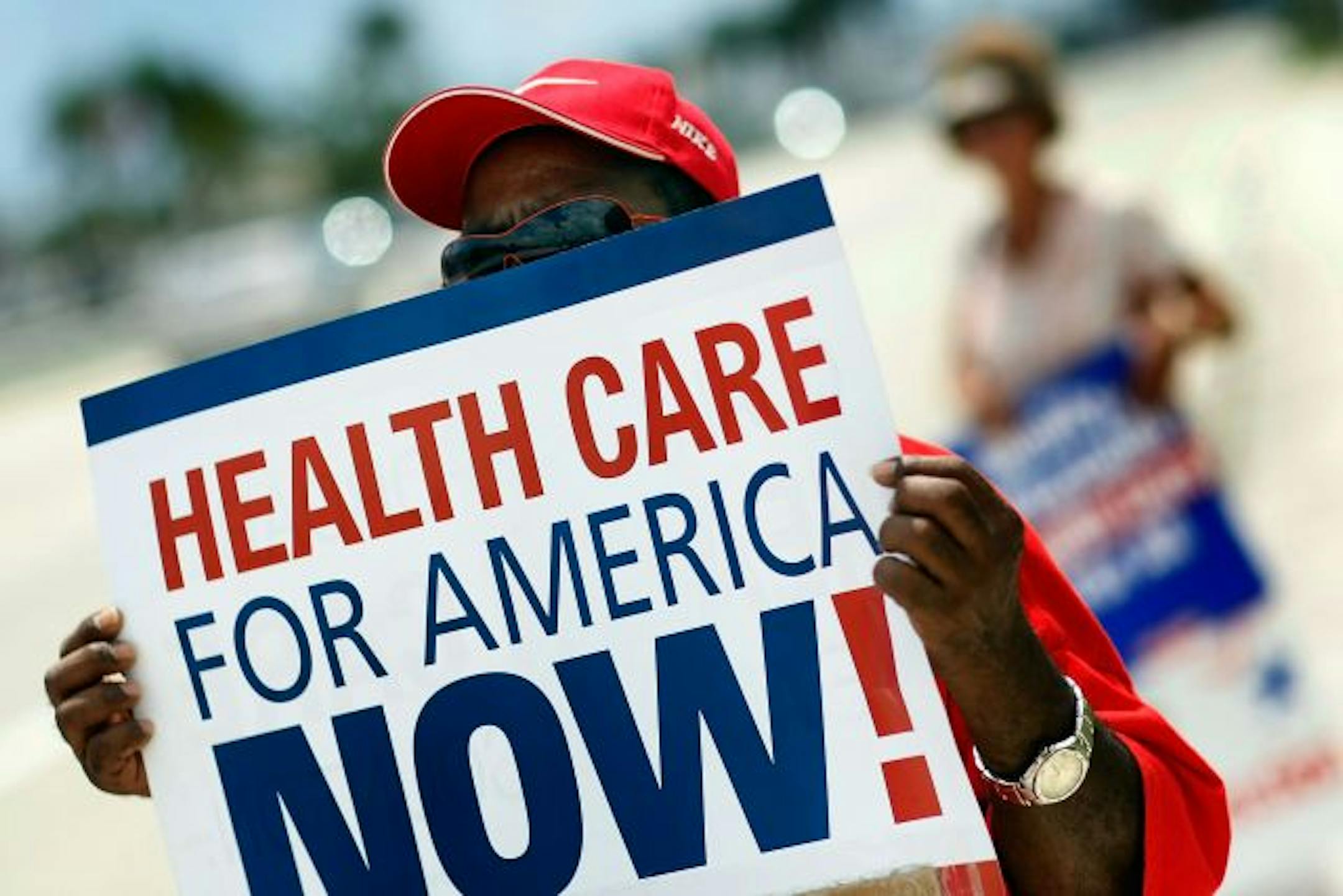 MIAMI - SEPTEMBER 02: Morris Pontifect shows his support for health care reform as he hopes that Senator Bill Nelson (D-FL) will see the sign as he attends the Greater Miami Chamber of Commerce Trustee's Luncheon at Jungle Island on September 2, 2009 in Miami, Florida. As President Barrack Obama plans to unveil his health care reform plan many people on both sides are making their voices heard.