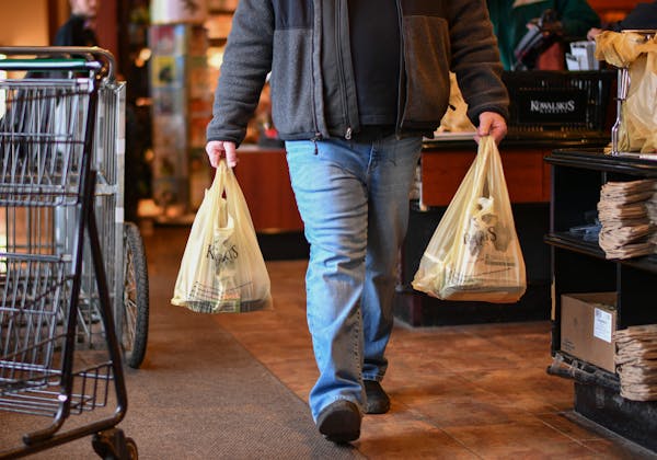 A customer carries bags out of a Kowalski’s grocery store in southwest Minneapolis in 2017.