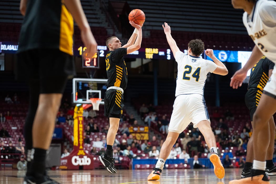 DeLaSalle’s Justin Johnson shoots a three-pointer over Totino-Grace’s Will Brands (24) in the first half of Thursday's Class 3A semifinal at Williams Arena.