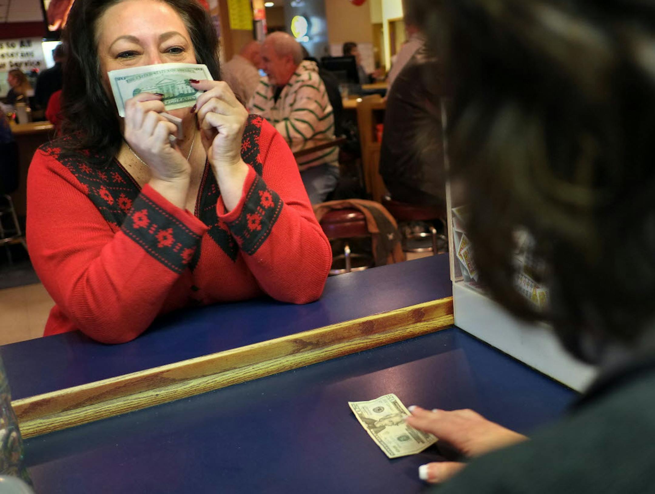 MariAnne Larson counts out $150 in pulltab winnings for Helen Branby of Brooklyn Park, who recently played at the Crystal VFW.