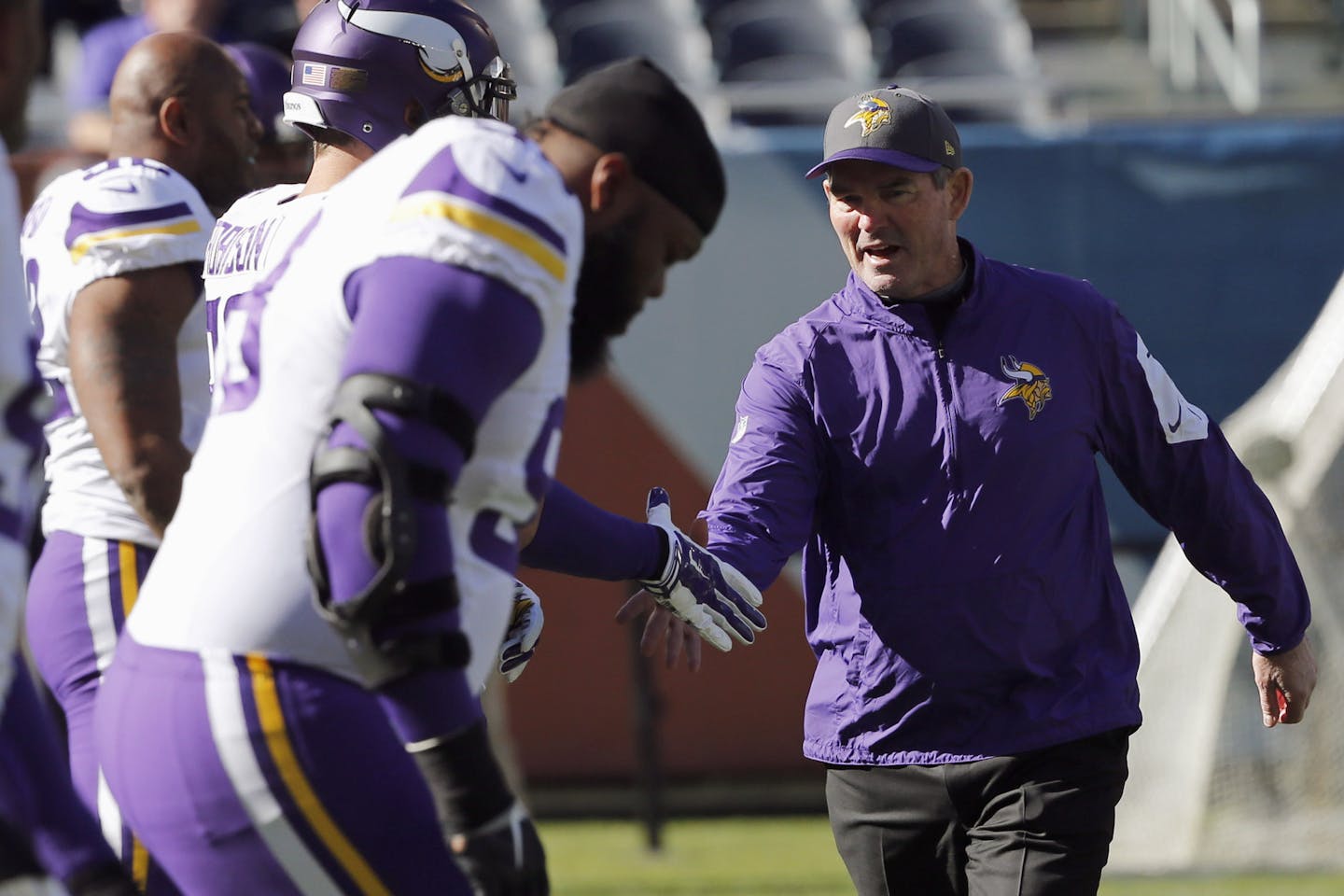 Minnesota Vikings head coach Mike Zimmer greets his players before an NFL football game against the Chicago Bears, Sunday, Nov. 1, 2015, in Chicago. (AP Photo/Charles Rex Arbogast)