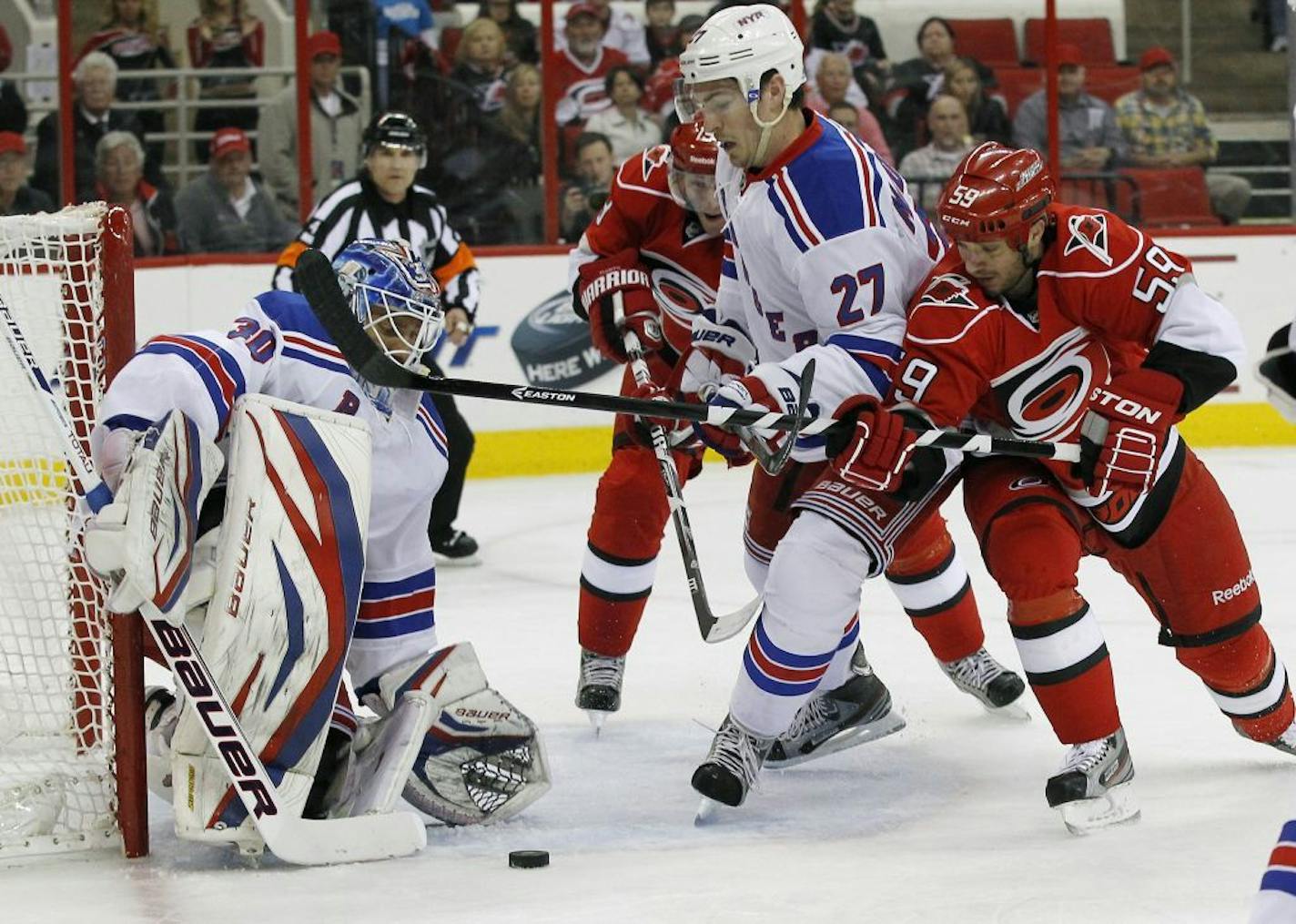 Carolina Hurricanes' Jiri Tlusty (19) and Chad LaRose (59) try to score against the New York Rangers' Michael Henrik Lundqvist (30) and Ryan McDonagh (27) during first-period action at PNC Arena in Raleigh, North Carolina, Thursday, April 25, 2013.