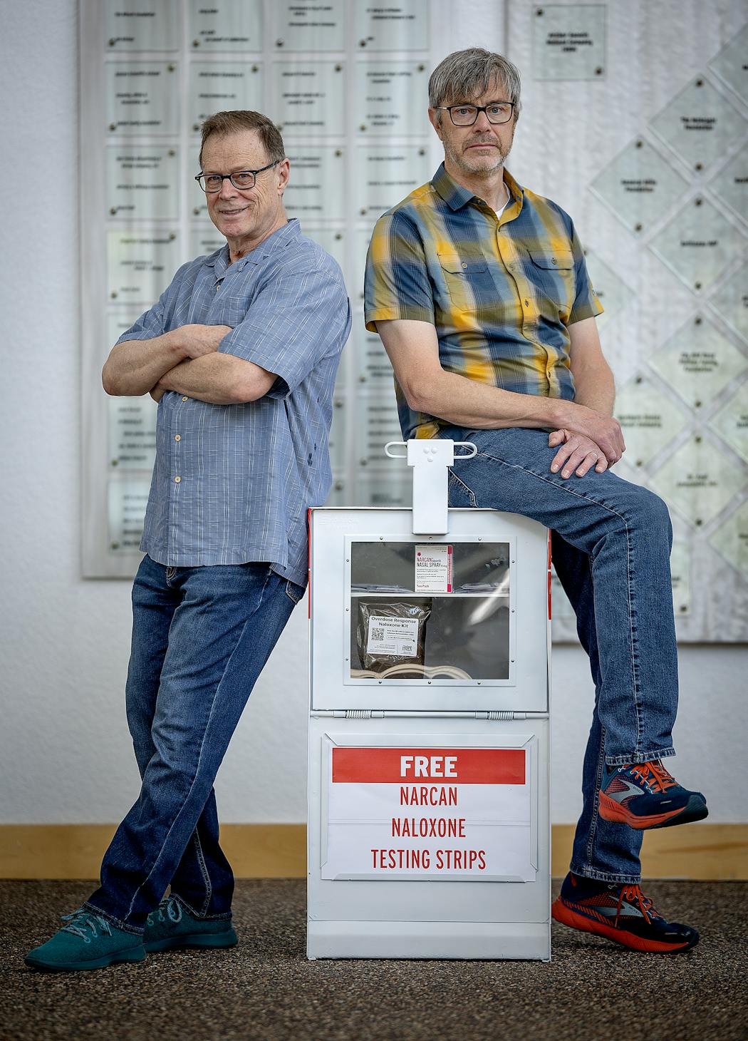 Jim Barrett, left, and Andrew Kamin-Lyndgaard with the former Star Tribune paper boxes they converted into free naloxone kit dispensers. They both were inspired to create the boxes, filled with Narcan and fentanyl detector strips, because of the rise in overdose deaths. The Star Tribune sells decommissioned paper boxes for $20 each.