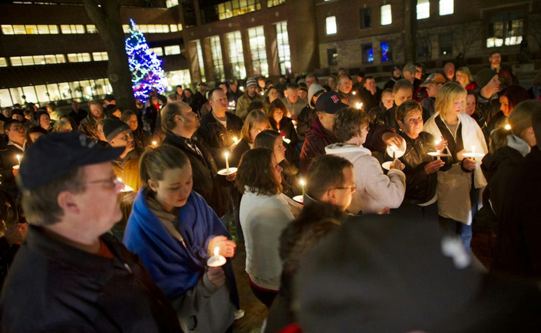 About 300 people gathered for a candlelight vigil for officer Shawn Schneider outside St. Marys Hospital on Tuesday.