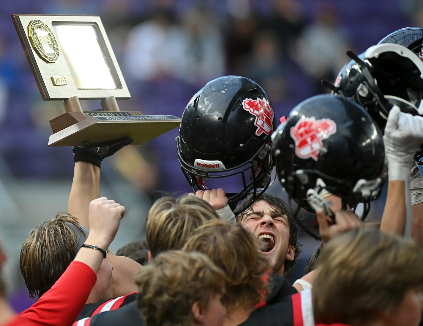 Mayer Lutheran tight end Teigan Martin (90), bottom right, celebrates with his team trophy after the Class 1A state championship football game between Minneota and Mayer Lutheran Friday, Nov. 26, 2021 at U.S. Bank Stadium in Minneapolis, Minn. ] AARON LAVINSKY • aaron.lavinsky@startribune.com