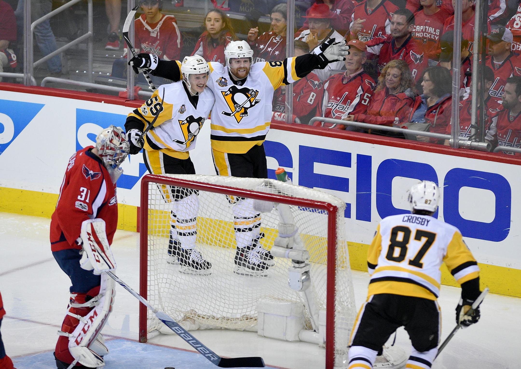 Pittsburgh Penguins right wing Phil Kessel (81) celebrates his goal with center Jake Guentzel (59) and Sidney Crosby (87) during the third period of Game 2 in an NHL hockey Stanley Cup second-round playoff series against Washington Capitals goalie Philipp Grubauer (31), of Germany, Saturday, April 29, 2017, in Washington. (AP Photo/Nick Wass)