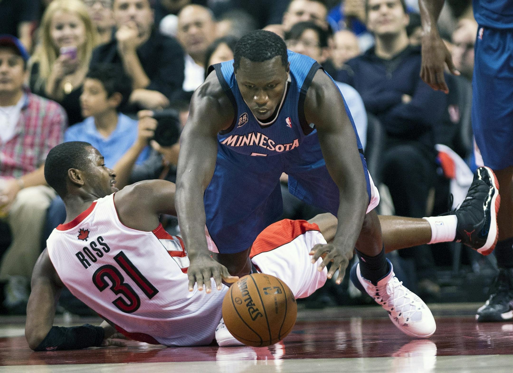 Toronto Raptors forward Terrence Ross, left, trips up Minnesota Timberwolves forward Gorgui Dieng during the second half of an NBA preseason basketball game in Toronto on Wednesday, Oct. 9, 2013. Dieng is playing Nikola Pekovic&#x2019;s minutes while Pekovic heals a bad ankle.