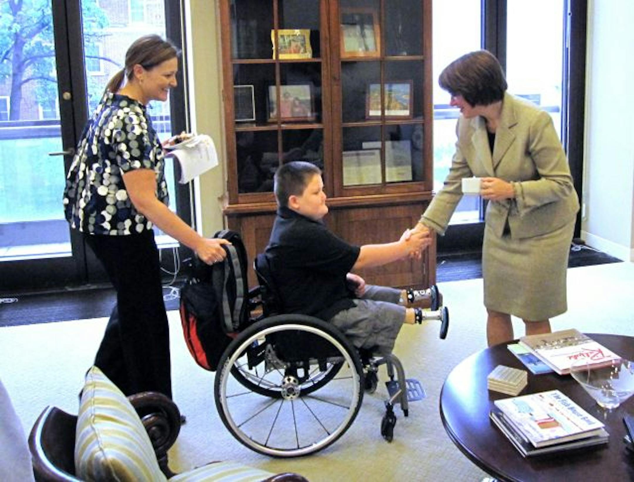 Photo courtesy of the Nelson familyTen-year-old Nicklas Nelson, center, of St. Paul, met with Minnesota Sen. Amy Klobuchar last week when he went to Washington to lobby Congress about the importance of keeping kids at the top of the health care agenda. Nelson lost both legs to a genetic abnormality.