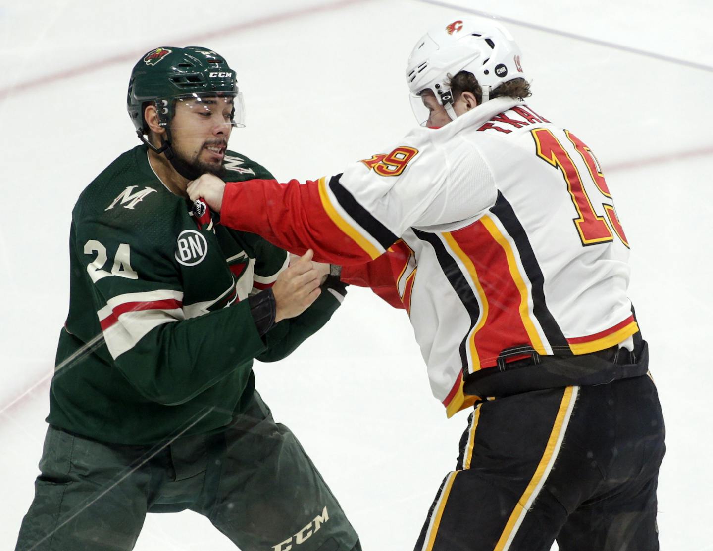 Minnesota Wild defenseman Matt Dumba (24)and Calgary Flames left wing Matthew Tkachuk (19) fight during the first period of an NHL hockey game Saturday, Dec. 15, 2018, in St. Paul, Minn. Calgary won 2-1. (AP Photo/Paul Battaglia)