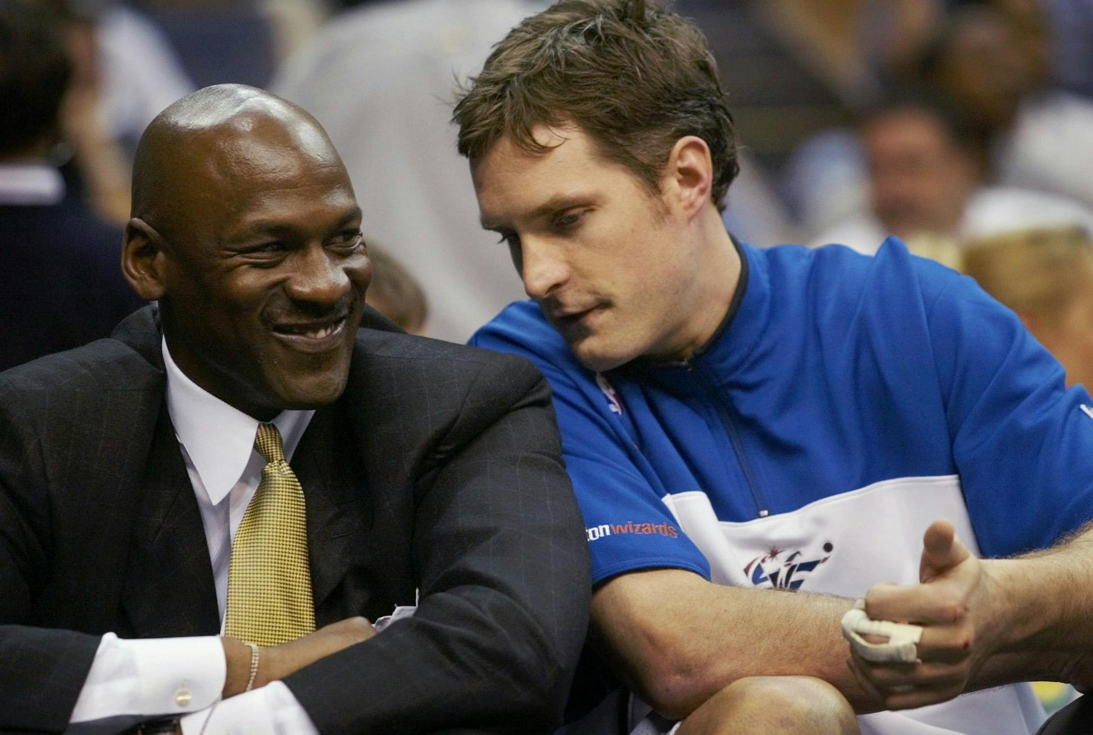 Washington Wizards' Michael Jordan, left, sits on the bench as he listens to teammate Christian Laettner during the closing minutes of the game against the Philadelphia 76ers Wednesday, April 10, 2002, in Washington. Jordan, who is out for the season due to a right knee inflammation, watched as the Wizards won 90-77. (AP Photo/Pablo Martinez Monsivais) ORG XMIT: MCI103