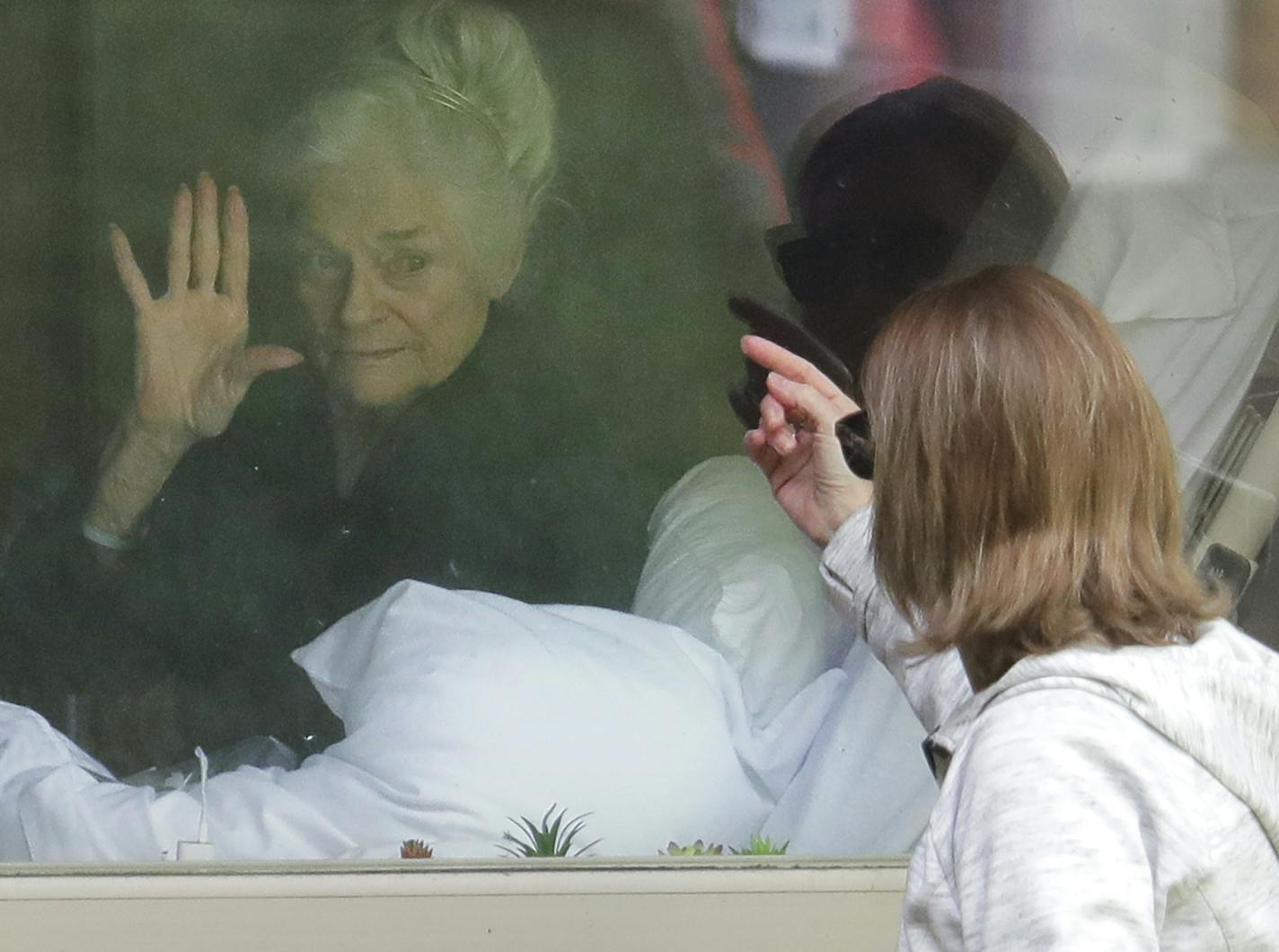 Judie Shape, who tested positive for coronavirus, visited with her daughter through a window in Washington state.