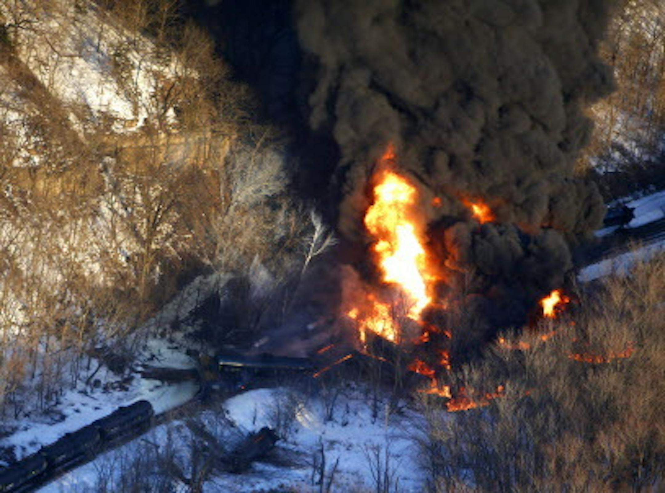 Smoke and flames erupt from the scene of a train derailment Thursday, March 5, 2015, near Galena, Ill. A BNSF Railway freight train loaded with crude oil derailed around 1:20 p.m. in a rural area where the Galena River meets the Mississippi, said Jo Daviess County Sheriff's Sgt. Mike Moser. (AP Photo/Telegraph Herald, Mike Burley)