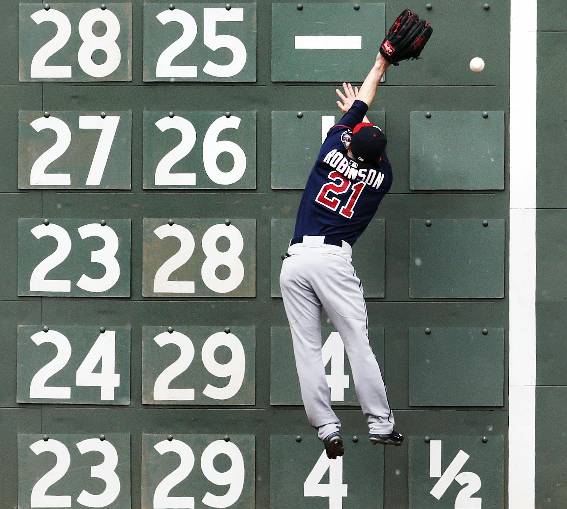 Minnesota Twins left fielder Shane Robinson leaps but can't make the catch on a double by Boston Red Sox designated hitter David Ortiz during the third inning in the first baseball game of a doubleheader at Fenway Park in Boston, Wednesday, June 3, 2015. (AP Photo/Charles Krupa)