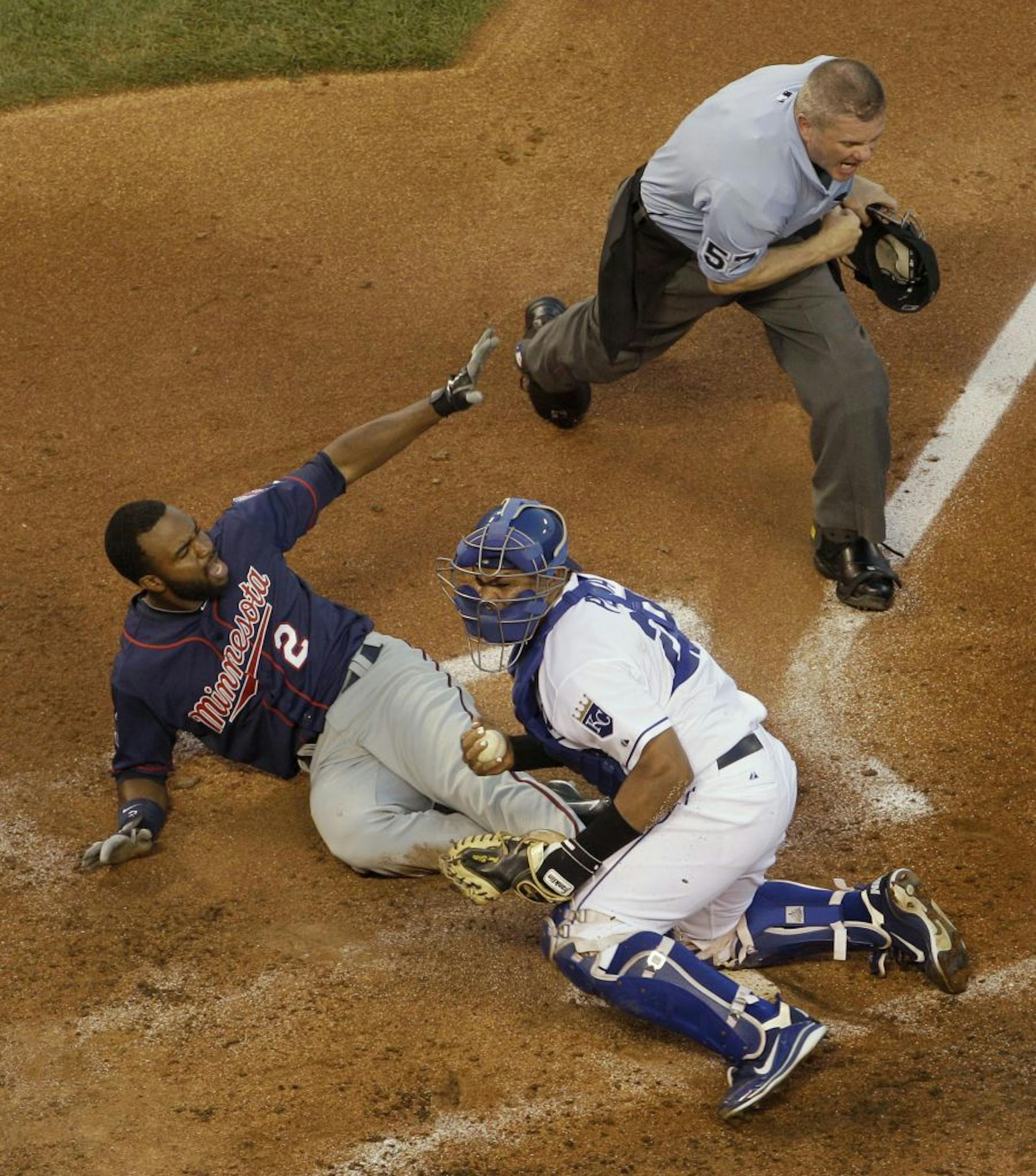 Minnesota Twins' Denard Span (2) looks for the call from home plate umpire Mike Everitt, top right, after being forced out at home by Kansas City Royals catcher Brayan Penawhile trying to stretch a triple during the fourth inning of a baseball game on Friday, June 3, 2011, in Kansas City, Mo.