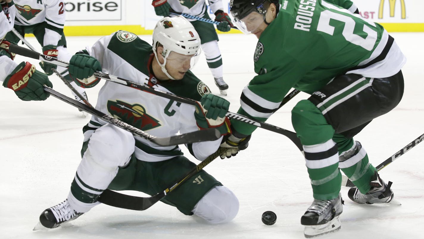 Minnesota Wild center Mikko Koivu (9) and Dallas Stars left wing Antoine Roussel (21) battle for the puck during the first period in Game 2 in the first round of the NHL Stanley Cup playoffs Saturday, April 16, 2016, in Dallas. (AP Photo/LM Otero)