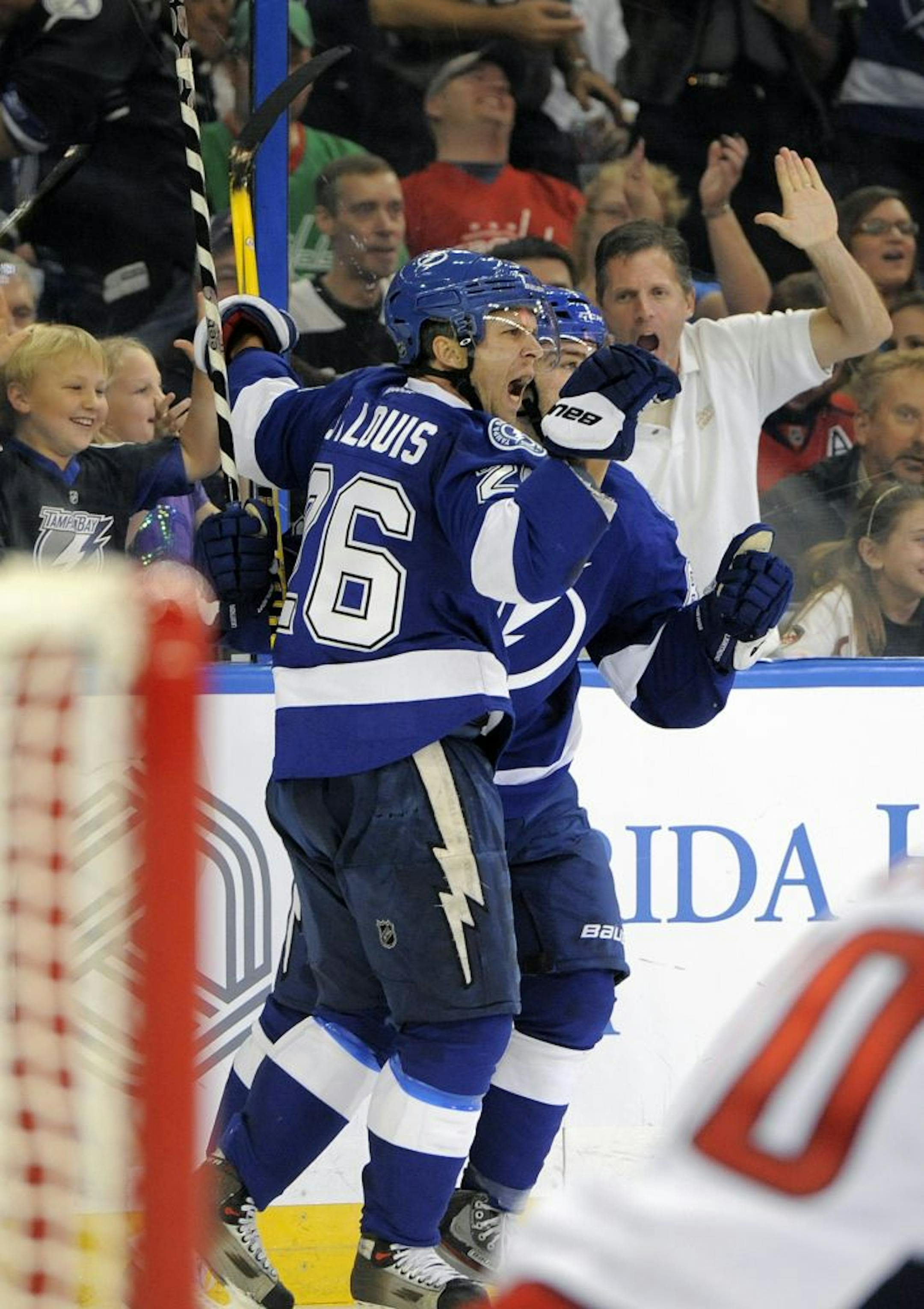 Tampa Bay Lightning right wing Martin St. Louis (26) celebrates with left wing Cory Conacher after scoring a goal on Washington Capitals goalie Braden Holtby during the second period of an NHL hockey game Saturday, Jan. 19, 2013, in Tampa, Fla.