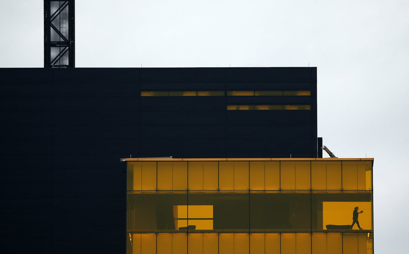 A worker cleaned the glass at the Guthrie Theater as heavy storm clouds loomed over downtown Minneapolis ahead of this weekend's snow storm. ] ANTHONY SOUFFLE &#xef; anthony.souffle@startribune.com The Twin Cities saw a wintery mix of rain and sleet just ahead of this weekend's megastorm expected to dump about 8 inches of snow on the area Friday, April 13, 2018 in Minneapolis.