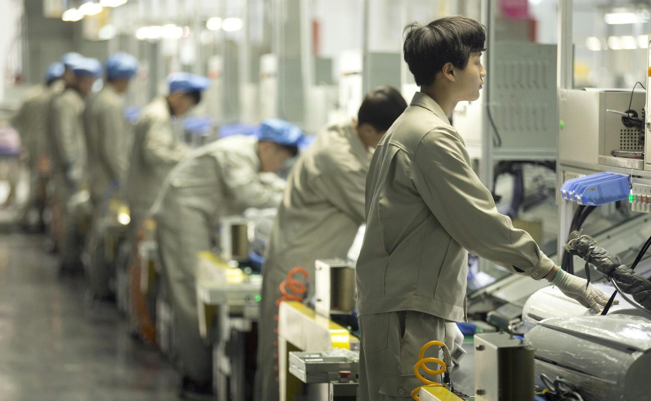 In this Friday, Feb. 24, 2017 photo, factory workers assemble the cases of air conditioners on an assembly line at a Haier factory in Jiaozhou near Qingdao in eastern China's Shandong Province. (AP Photo/Mark Schiefelbein)