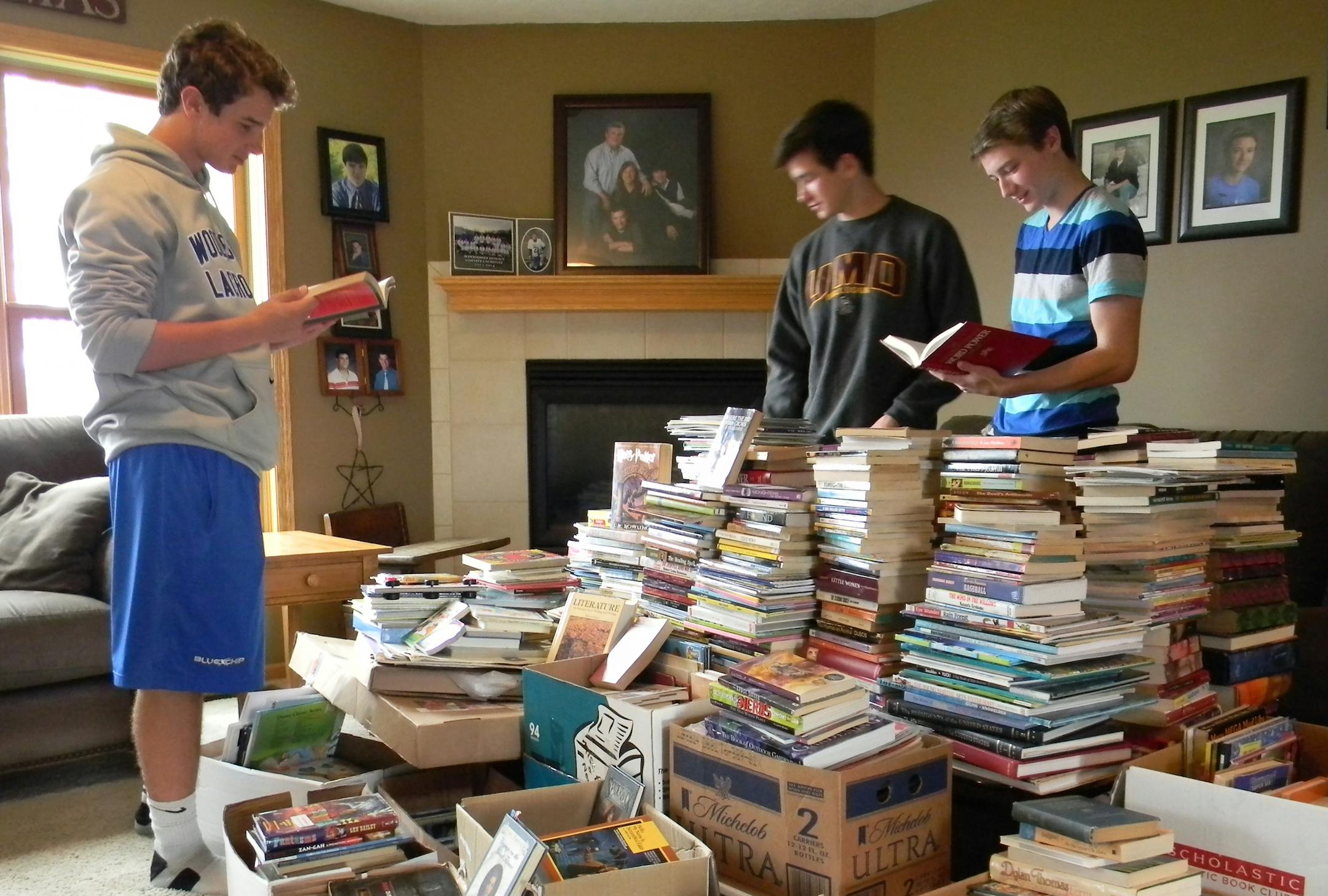 Gavin Thomas, right, with friends Chip Shimota, center, and Chris Rolfing, left, sort through books they've collected.