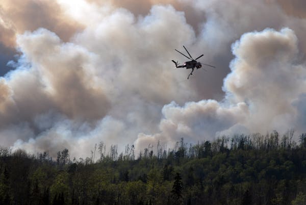 A service helicopter dumps water on a back burn along the Gunflint Trail in 2007.
