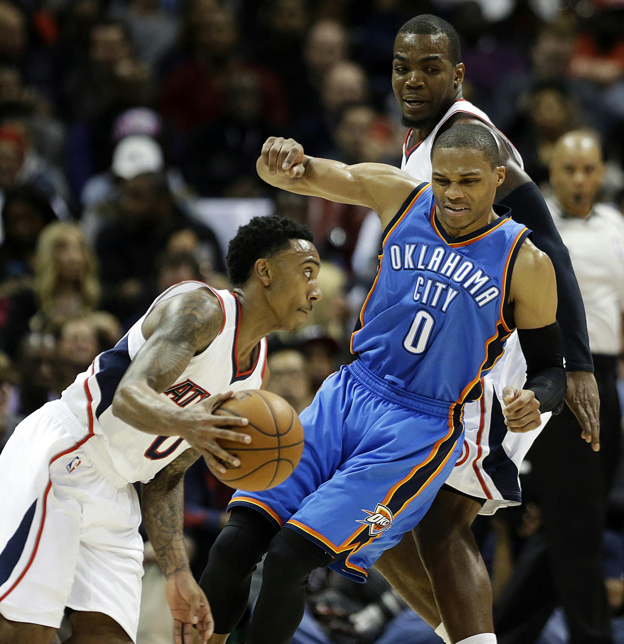 Oklahoma City Thunder's Russell Westbrook (0), right, tries to move through a pick set by Atlanta Hawks' Paul Millsap, rear, as Hawks' Jeff Teague, left, dribbles the ball during the third quarter of an NBA basketball game, Friday, Jan. 23, 2015, in Atlanta. The Hawks won 103-93. (AP Photo/David Goldman)