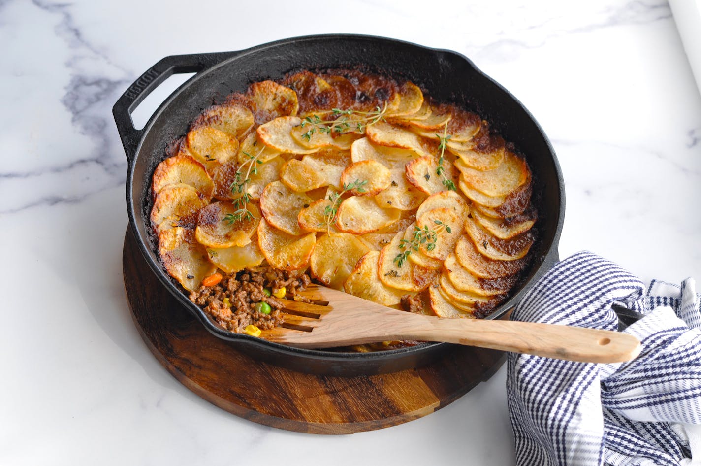 Cottage pie, a version of shepherd's pie made with hamburger and vegetables, is topped with sliced potatoes instead of mashed.