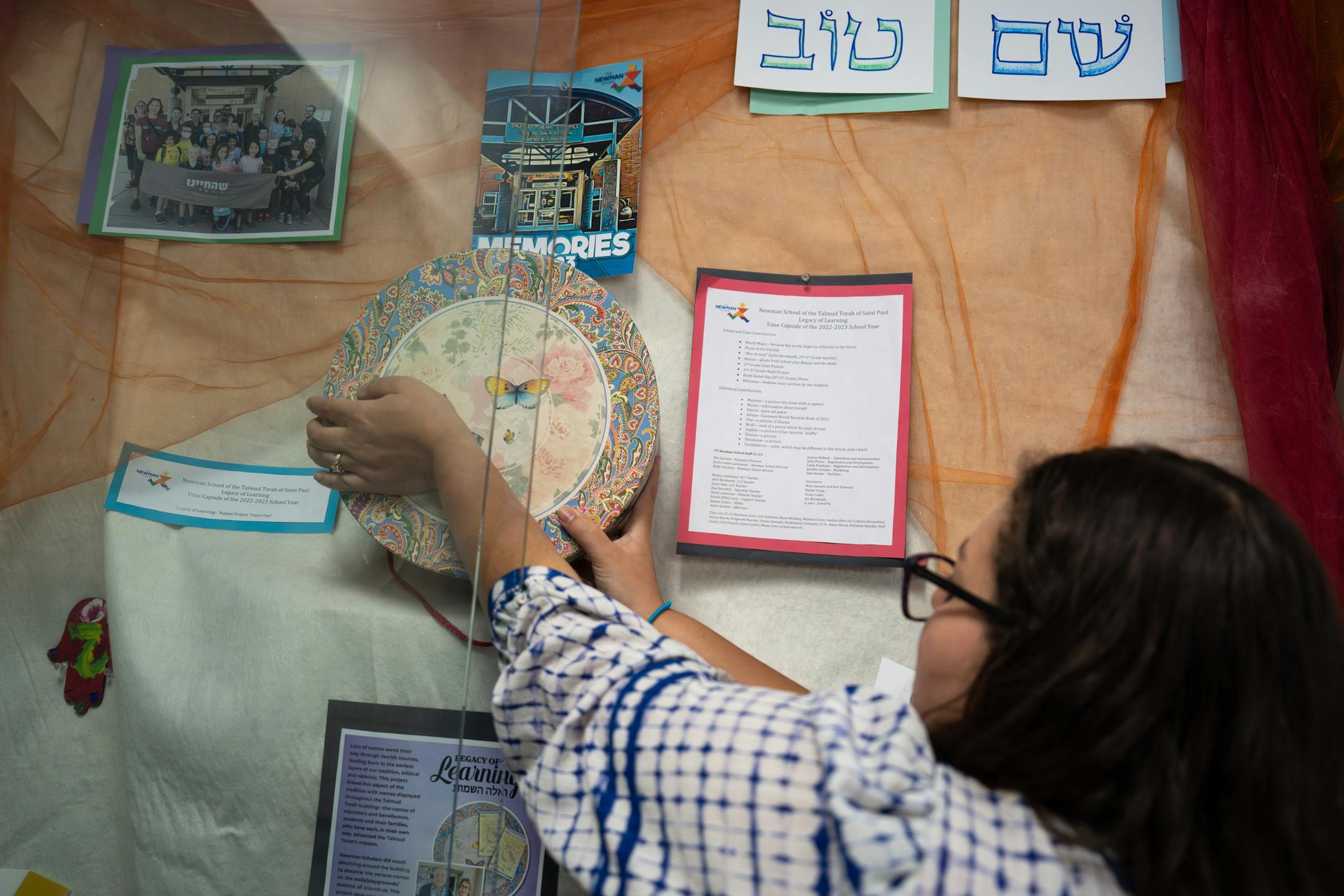 Principal Jessie Lavintman took the time capsule from its temporary display so the students could look inside one more time Friday, June 2, 2023 St. Paul, Minn. Students at the Newman School — part of Talmud Torah, a Jewish day school in St. Paul — built a time capsule on Friday. After learning about the history of the founders of their school, they're sending a little bit of their own history into the future.