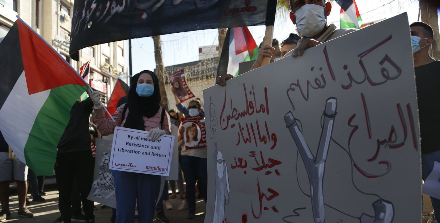 Palestinians demonstrate against Israeli plans for the annexation of parts of the West Bank, in the in the West Bank city of Ramallah, Wednesday, July 1, 2020.The Arabic reads : " This is how we understand conflict, either Palestine, or fire, generation after generation". (AP Photo/Majdi Mohammed)