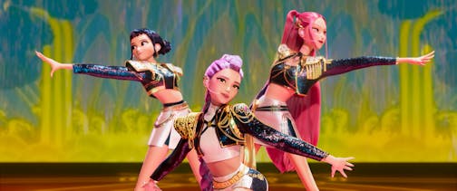 An animated still shows three female performers on a stage with outstretched hands and outfits featuring bolero jackets, bare midriffs and skirts.