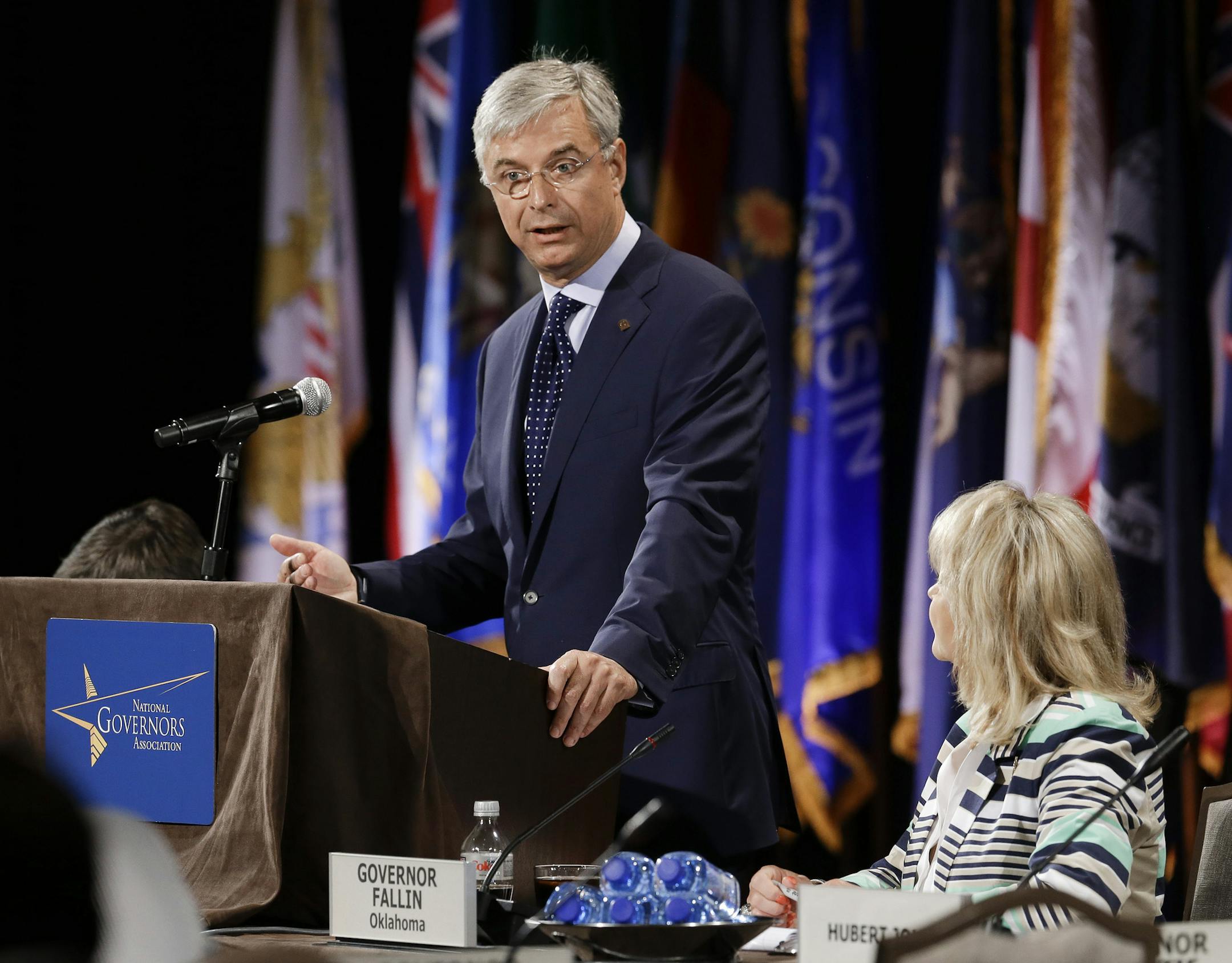 Hubert Joly, left, president and CEO of Best Buy, addresses the closing session of the National Governors Association convention Sunday, July 13, 2014, in Nashville, Tenn. At right is Oklahoma Gov. Mary Fallin. (AP Photo/Mark Humphrey)