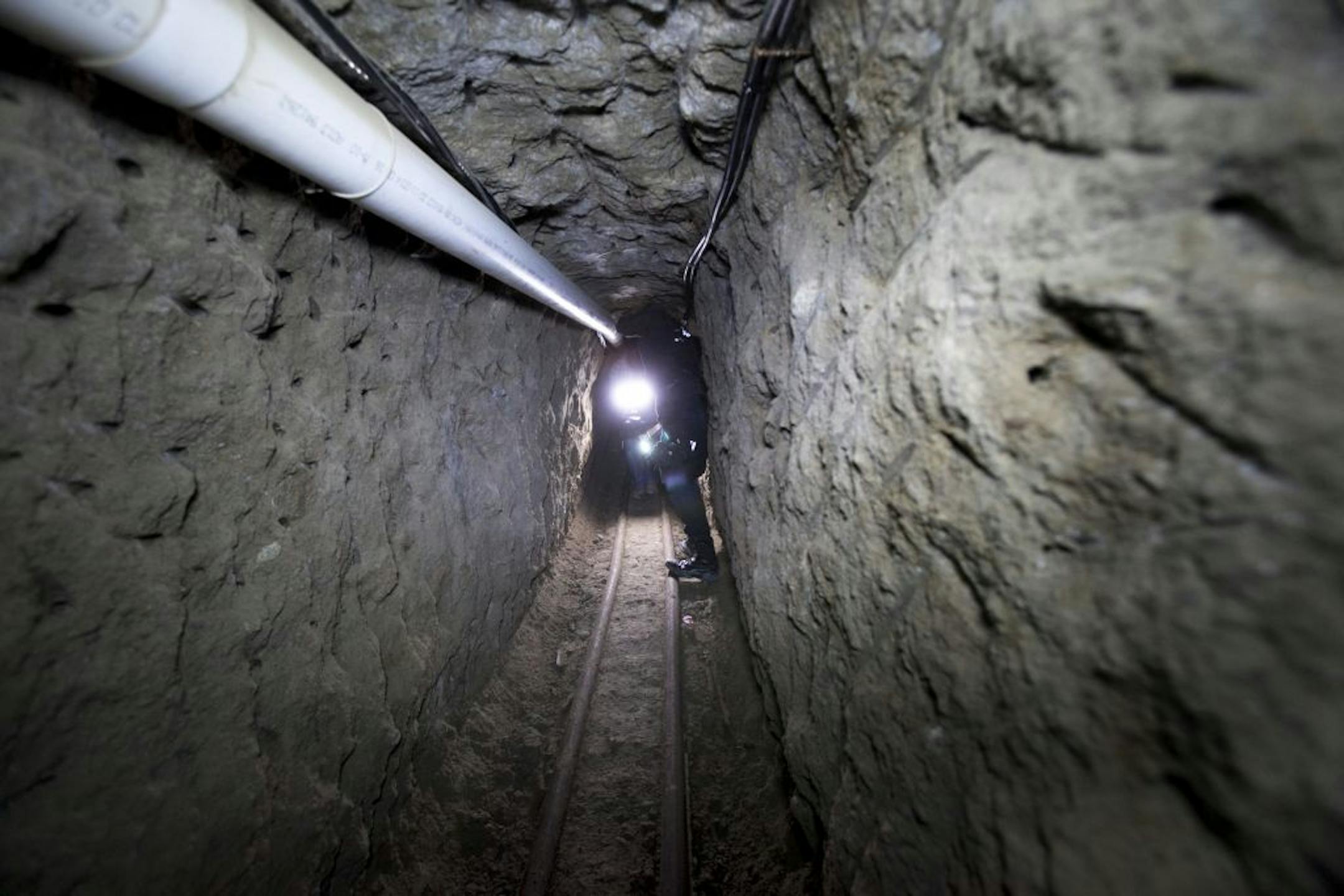 Federal Police officer stands in the tunnel where according to authorities drug lord Joaquin "El Chapo" Guzman made his escape from the Altiplano maximum security prison in Almoloya, west of Mexico City, Thursday, July 16, 2015. Two Mexican lawmakers say at least 18 minutes had elapsed from when Mexico's most prized prisoner slipped into a mile-long tunnel Saturday night and when authorities became aware. An official with the National Security Commission said he would try to confirm the figure,