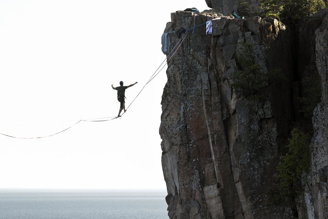 Slackliner Mark Mckee walks the line 300 feet above the water at Palisade Head. The line was 580 feet long between the cliffs.