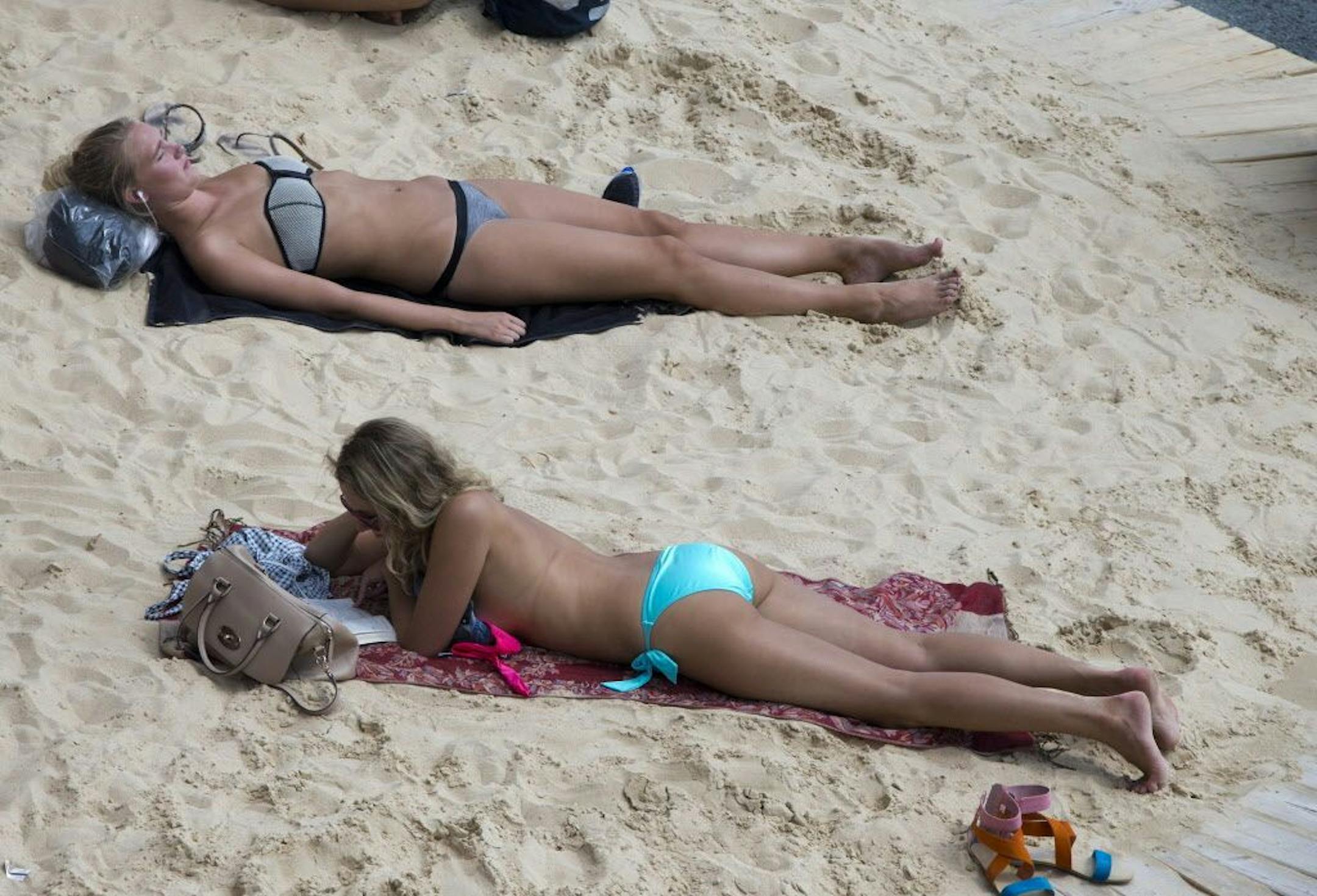 In this Aug. 5, 2014 photo, tourists and Parisians take advantage of the Paris Plage event, an artificial beach set up on the right bank of the Seine river in Paris.