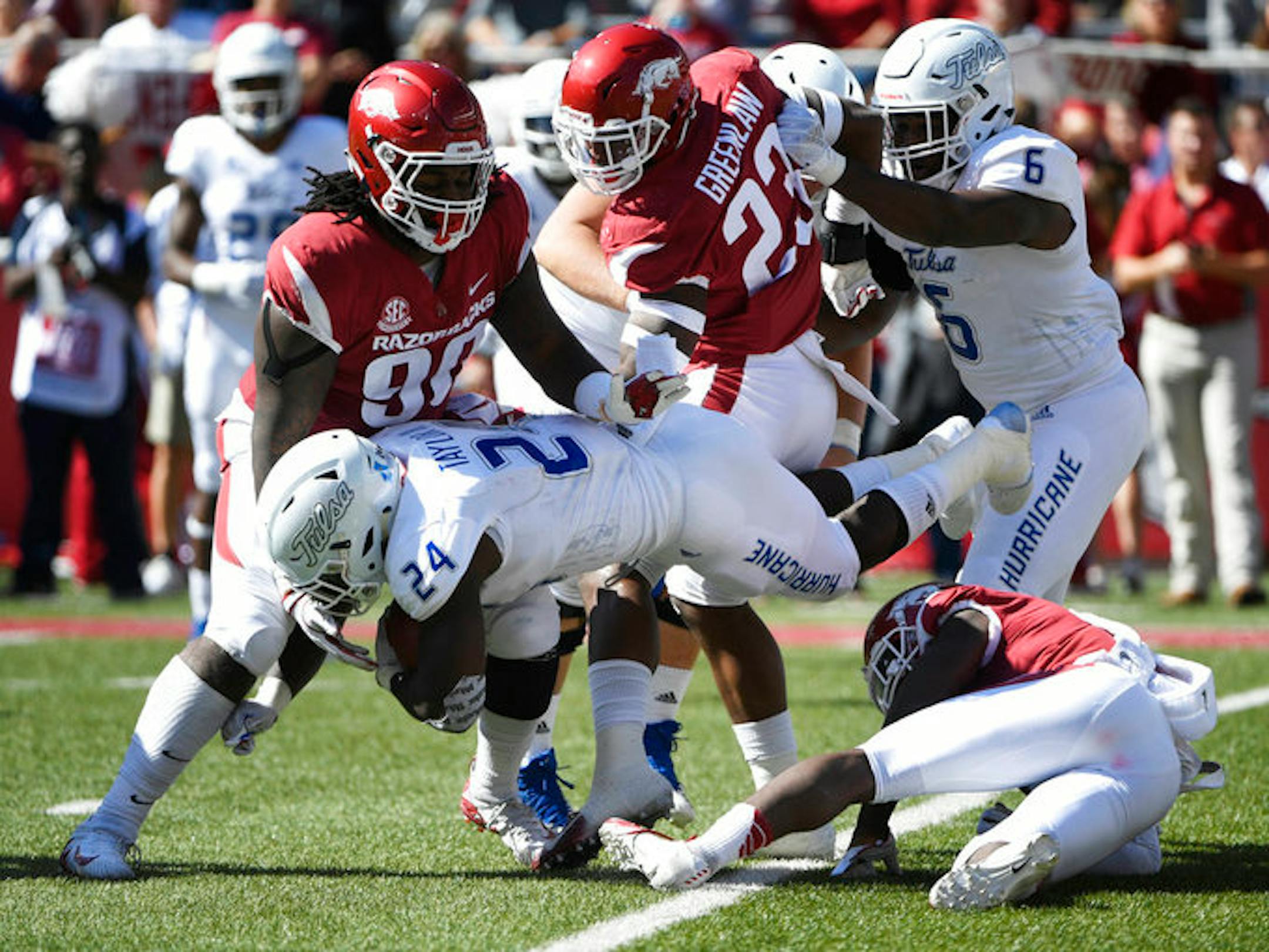 Tulsa running back Corey Taylor II is tackled by Arkansas defenders Kamren Curl, Armon Watts (90) and Dre Greenlaw (23) in the second half of an NCAA college football game Saturday, Oct. 20, 2018, in Fayetteville, Ark. (AP Photo/Michael Woods)