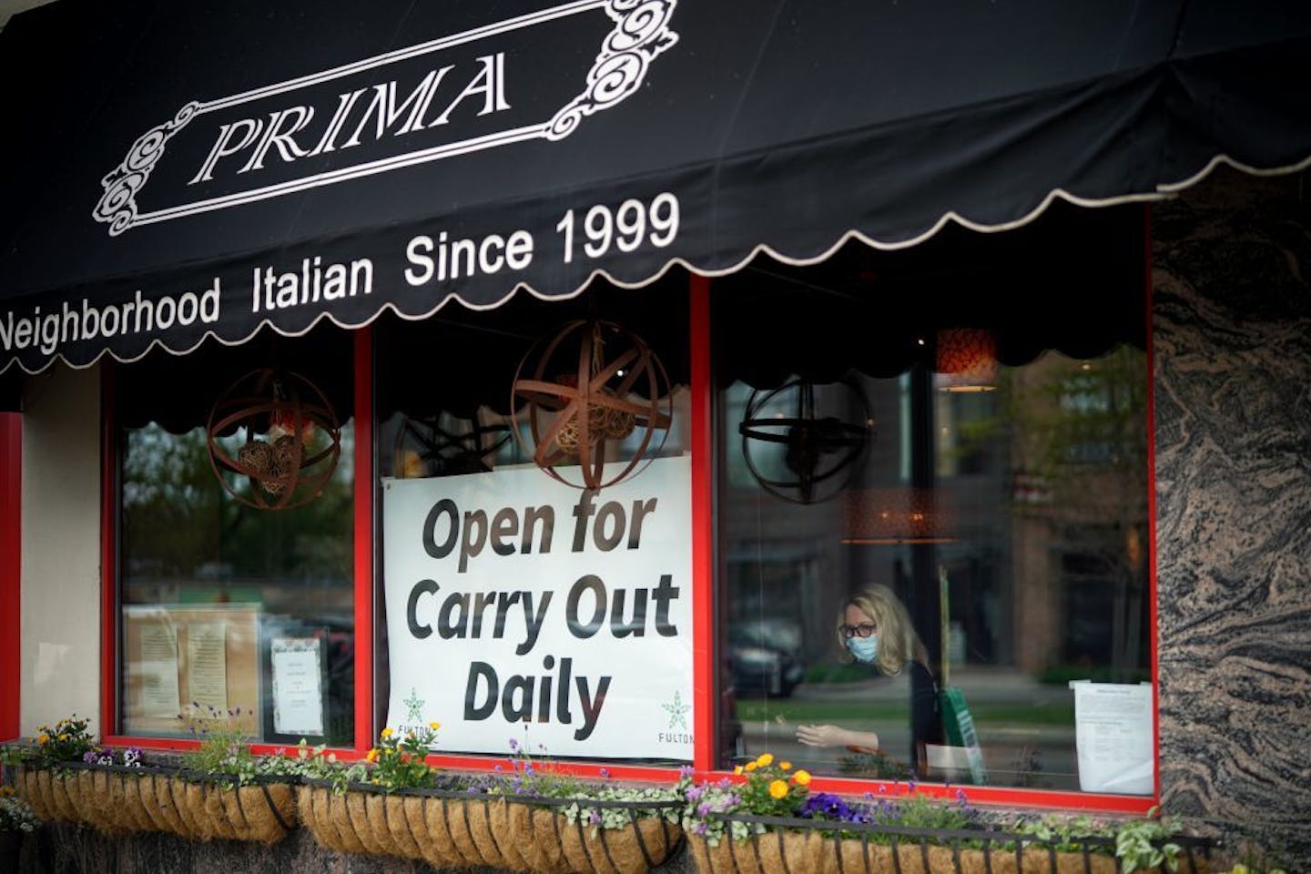 Jennifer King, owner of Prima, kept an eye on the food delivery parking spots in front of her restaurant on Lyndale Ave and she delivered their orders. In between deliveries, she checked for incoming orders on her phone.