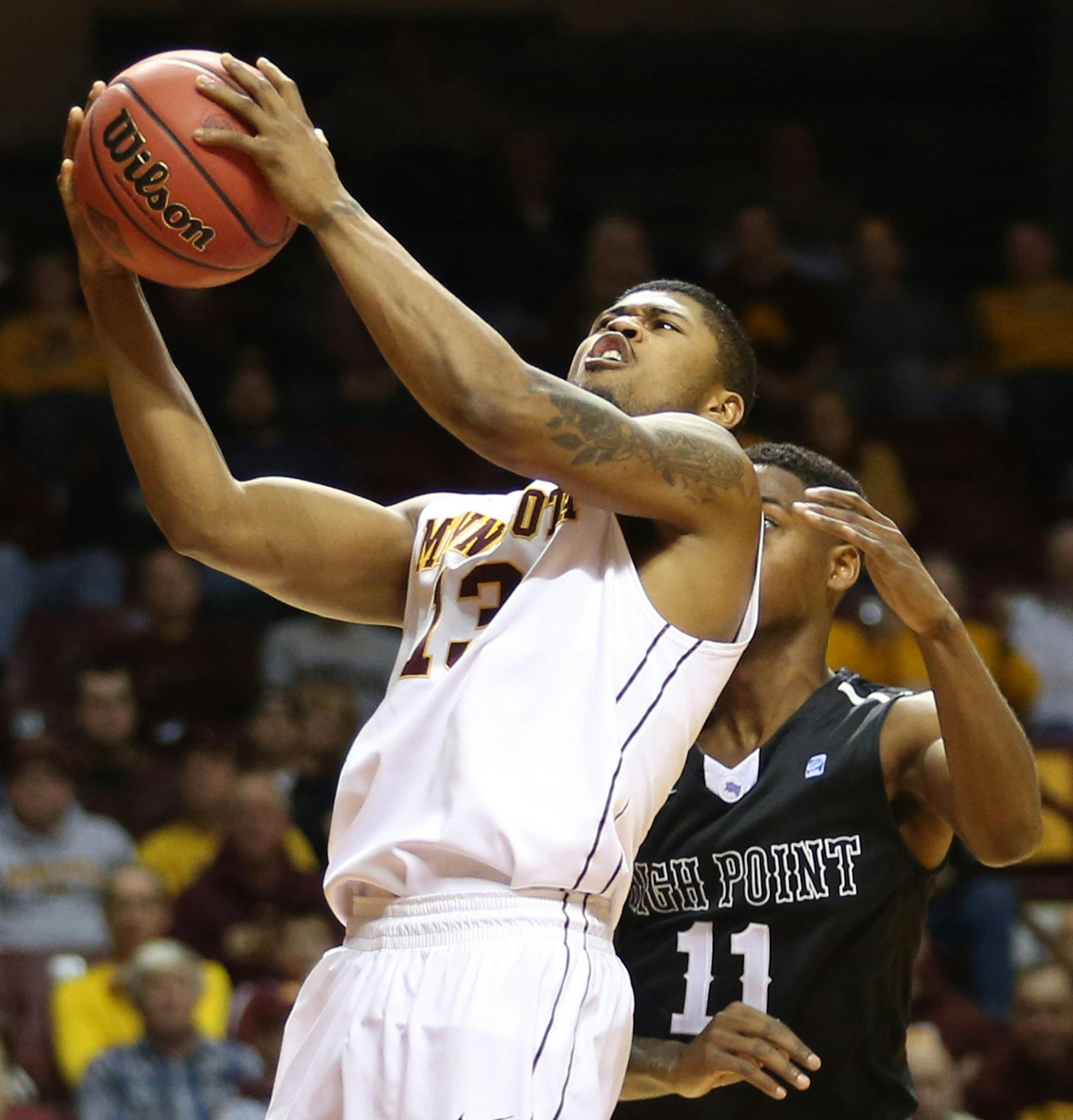 Gopher Maverick Ahanmisi went up with the ball with High Point's Haiishen McIntyre defending in the second half. ] (KYNDELL HARKNESS/STAR TRIBUNE) kyndell.harkness@startribune.com First round of the National Invitational Tournament at Williams Arena in Minneapolis Min, Tuesday March 18, 2014. Gophers won 88-81 over High Point.