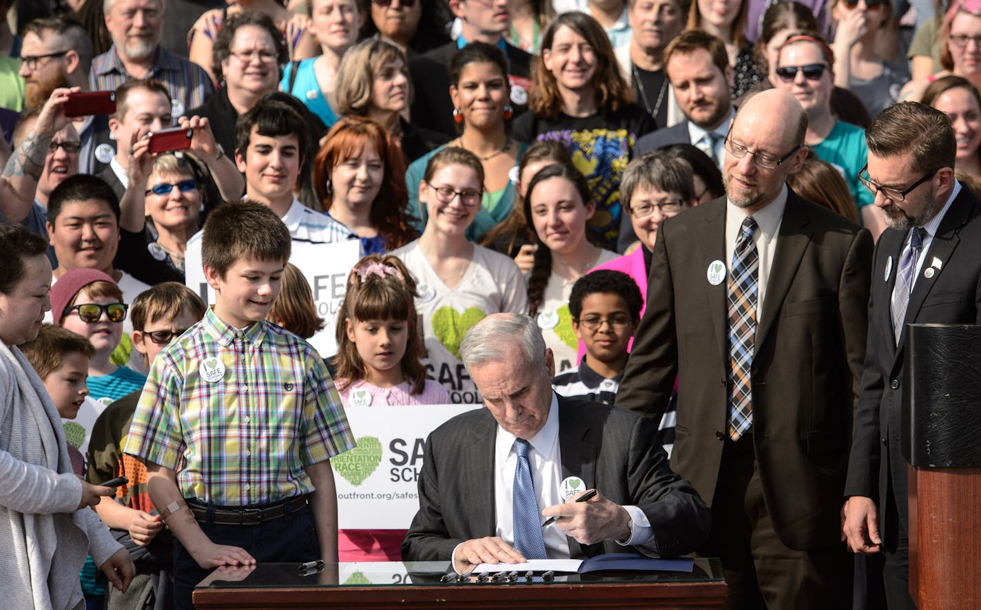 Governor Mark Dayton signed the Safe and Supportive Schools Act on the steps of the Minnesota State Capitol. Sponsors of the anti-bullying bill, State Rep. Jim Davnie and State Sen. Scott Dibble on the right and 11-Year-Old Boy Scout Jake Ross, left. ] GLEN STUBBE * gstubbe@startribune.com Wednesday, April 9, 2014