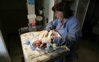 DAVID JOLES � djoles@startribune.com Unity Hospital obstetrician Lynn Rydberg, right, checks the vitals of newborn during an exam on Tyler Vang, bor
