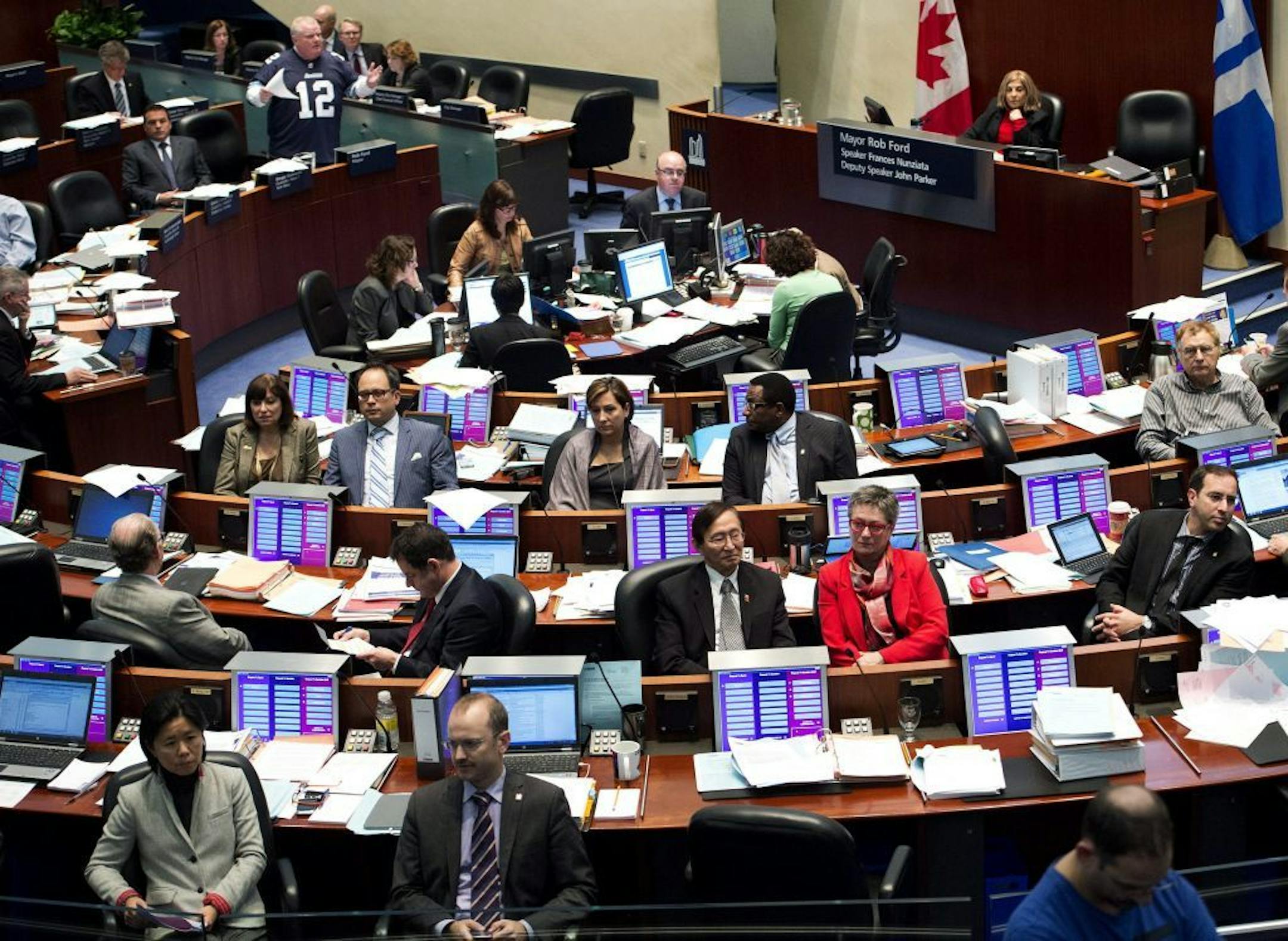 City Council members turn their backs in protest as Toronto Mayor Rob Ford, standing top left, addresses the council during a session at City Hall in Toronto on Thursday, Nov. 14, 2013.