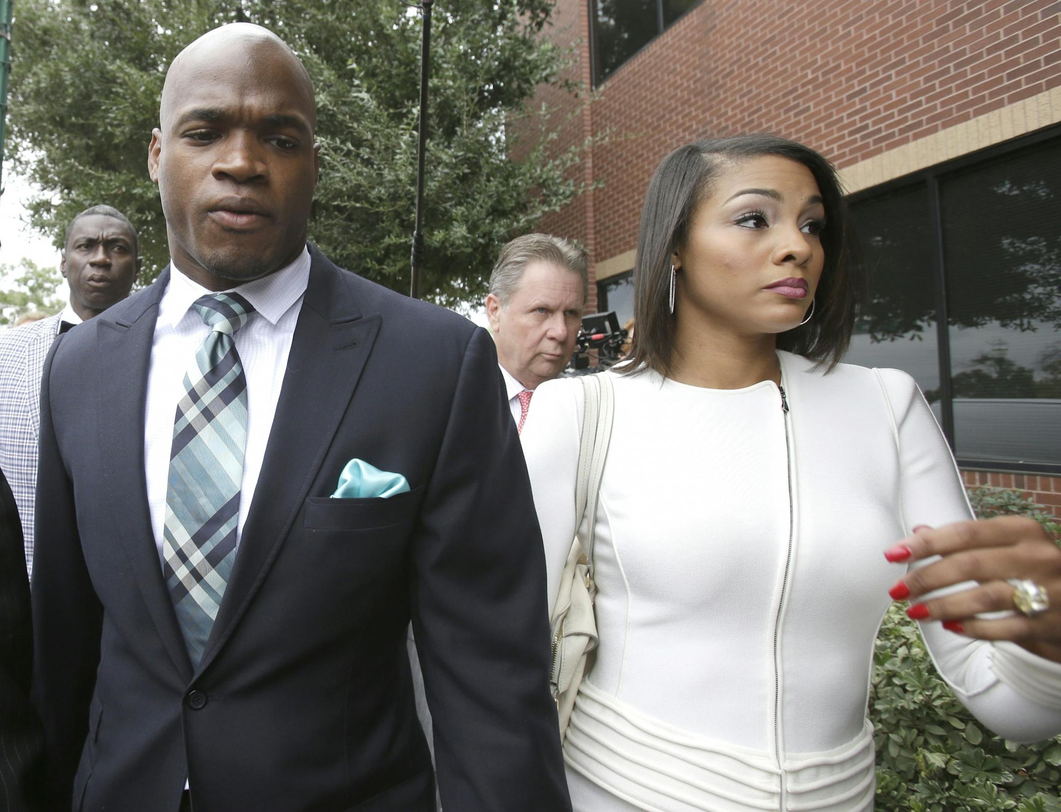 Minnesota Vikings running back Adrian Peterson arrives at the courthouse with his wife Ashley Brown Peterson, right, for an appearance Tuesday, Nov. 4, 2014, in Conroe, Texas.