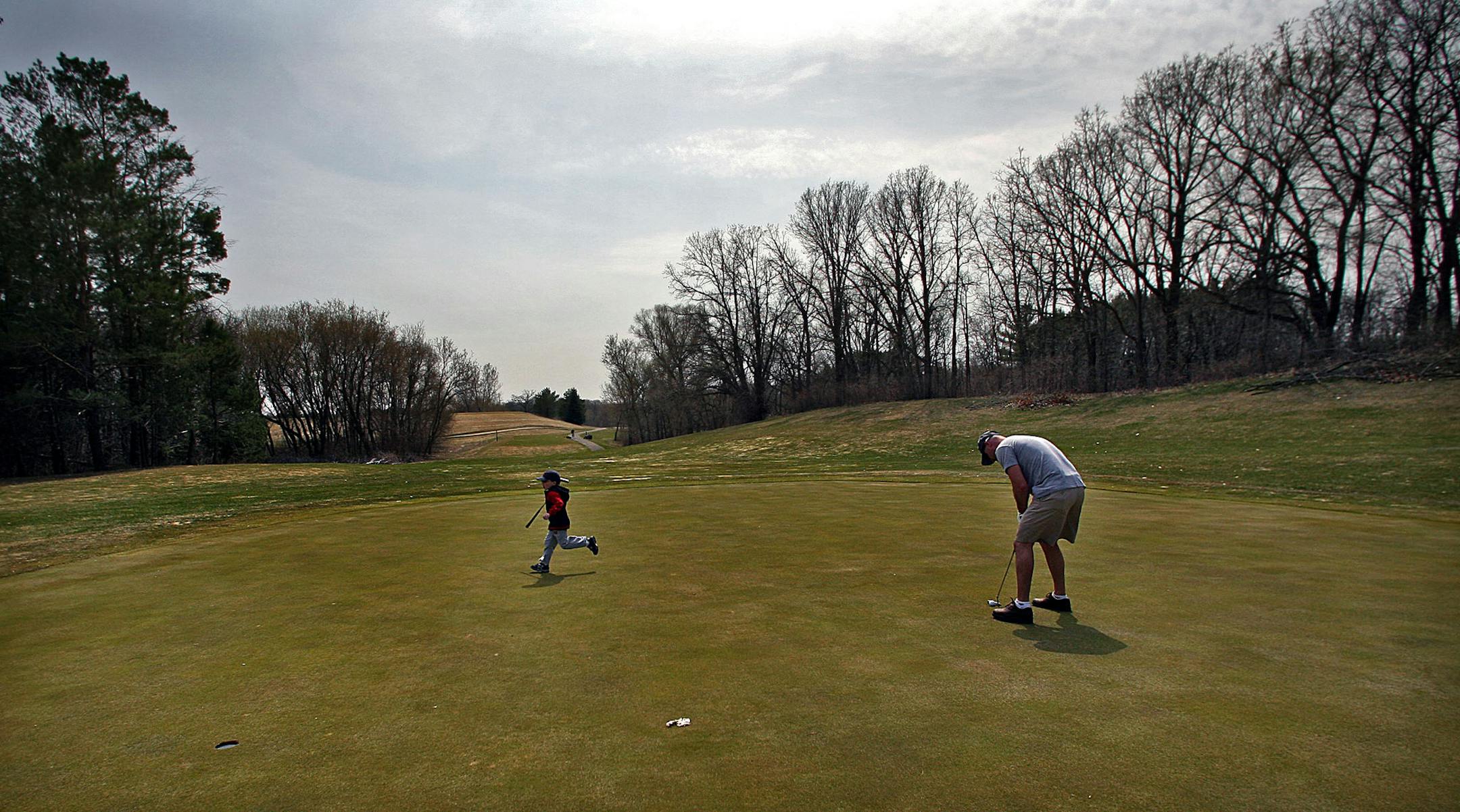 JIM GEHRZ ï jgehrz@startribune.com Inver Grove Heights/April 18, 2009/1:30PM An enthusiastic five-year-old Jack Knoll ran to a golf cart after he finished putting on the fifth hole of the executive 9 hole golf course at at Inver Wood Golf Course in Inver Grove Heights. Some cities are finding that municipal golf courses are becoming a financial drain in the current economic climate. Jackís father, Karry (cq), is putting at right.